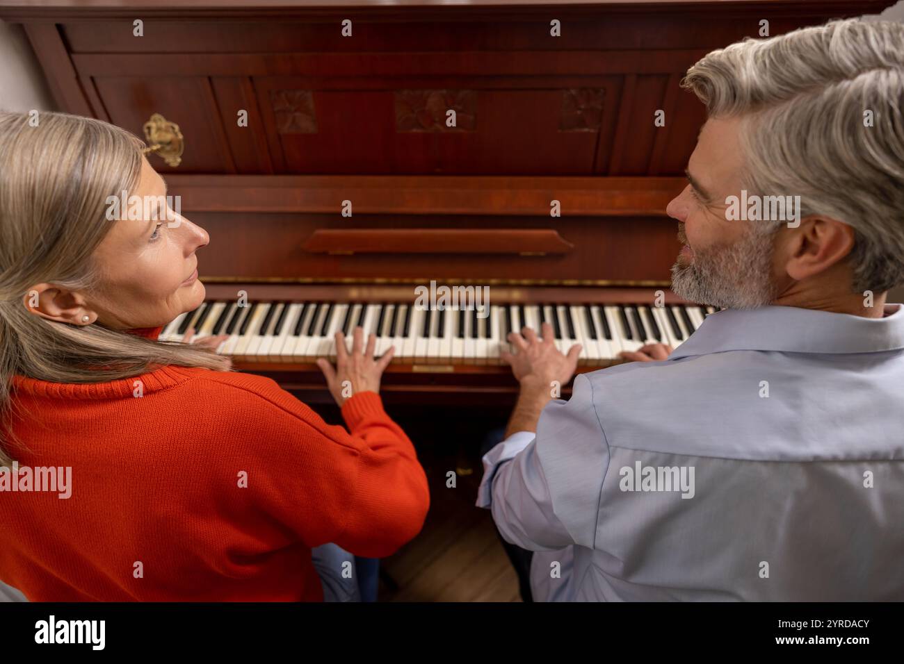 Femme mature ayant un cours de musique avec un professeur masculin Banque D'Images