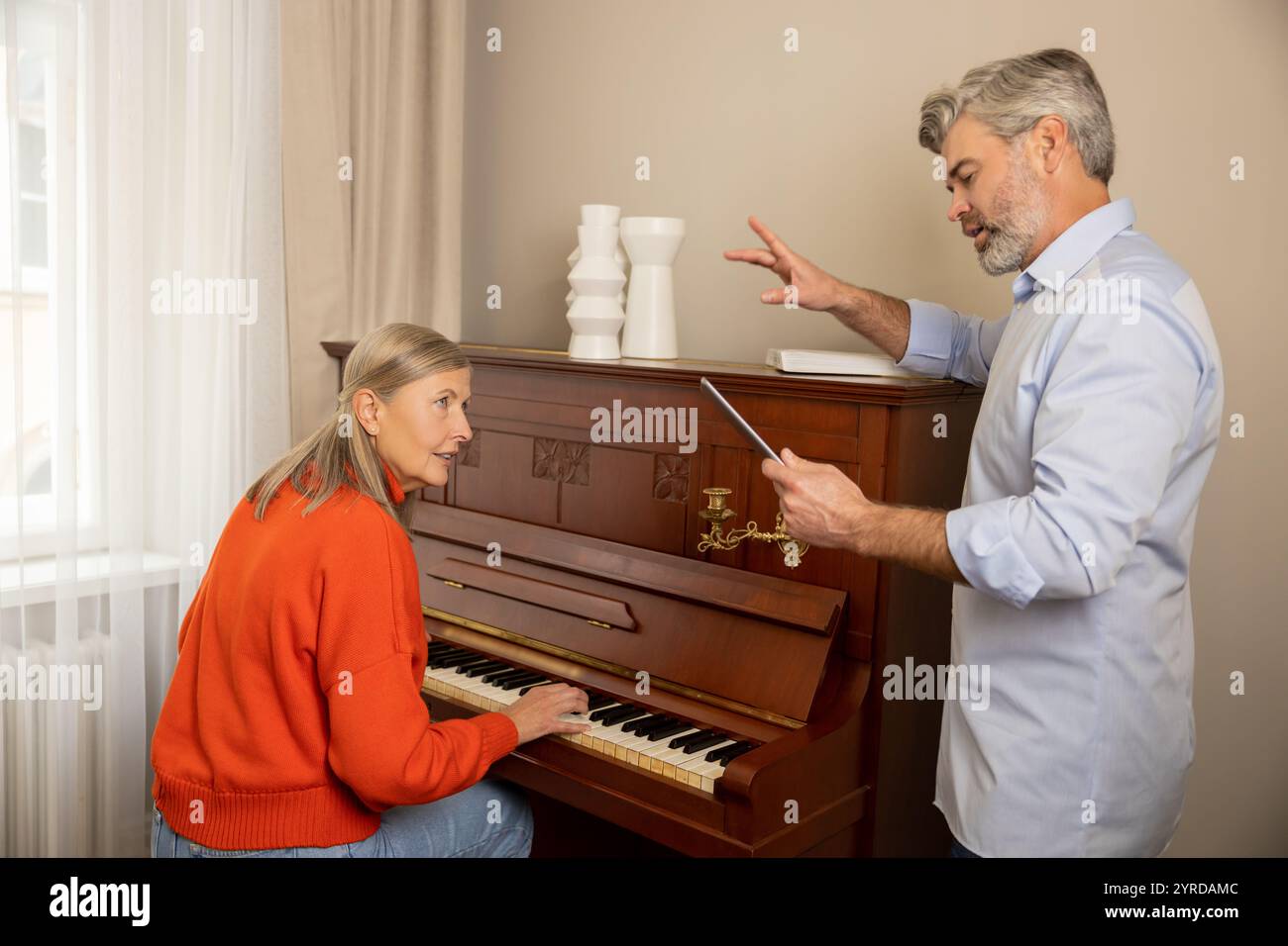 Femme mature ayant un cours de musique avec un professeur masculin Banque D'Images