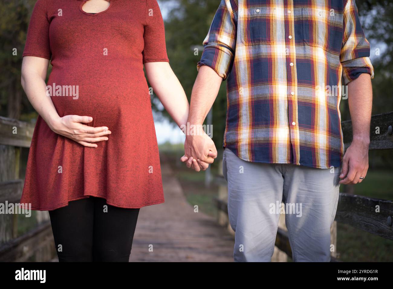 Couple attendu tenant la main sur un chemin en bois rustique en automne Banque D'Images