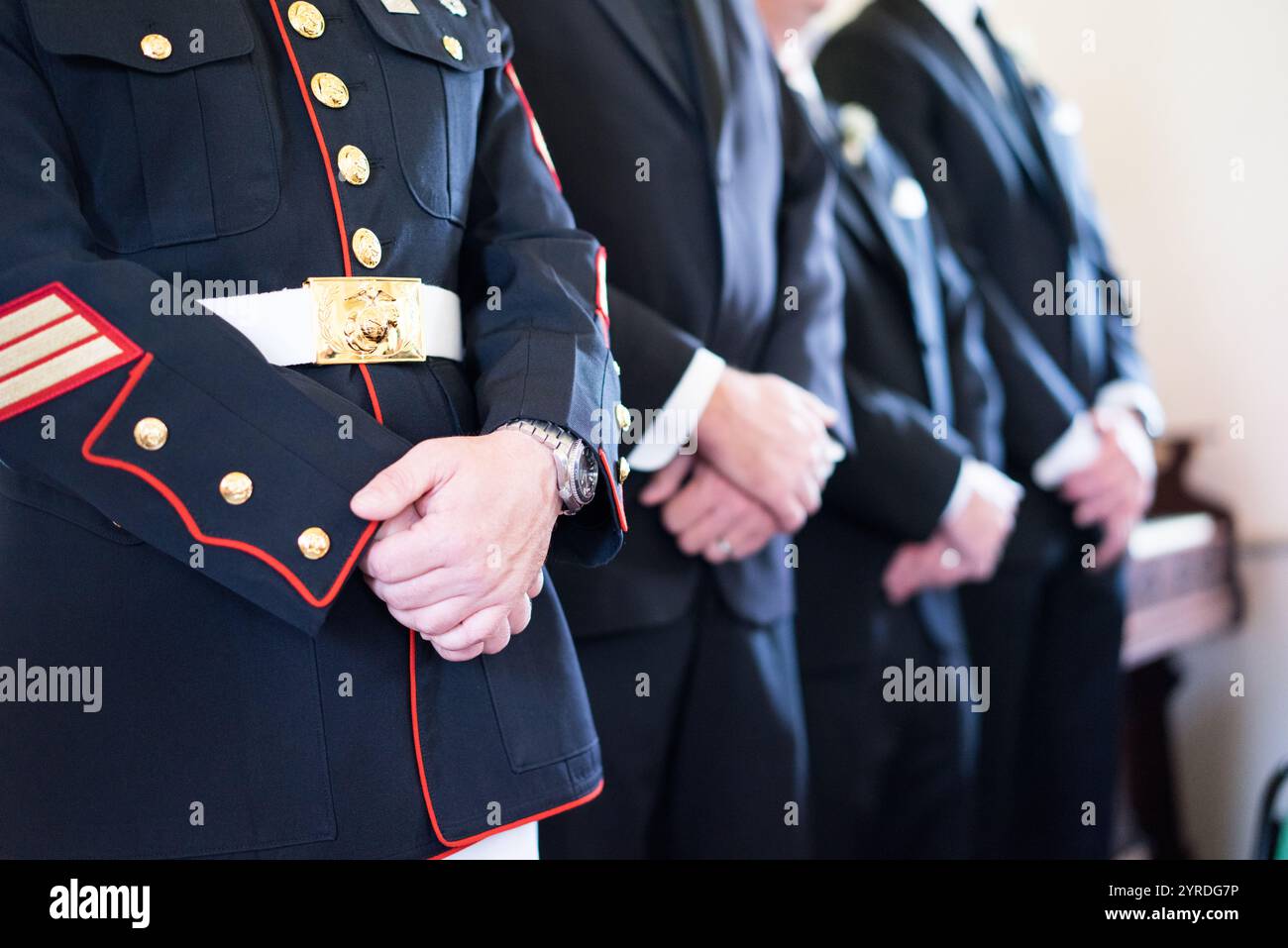 Groomsman militaire debout dans la ligne avec la fête de mariage en costumes Banque D'Images