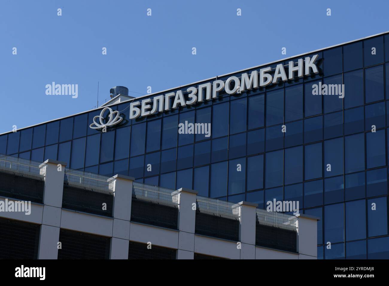 Mogilev, Biélorussie - 21 juin 2024 : un bâtiment de banque élégant et moderne présente un design contemporain avec de grandes fenêtres en verre reflétant le bleu vif s. Banque D'Images