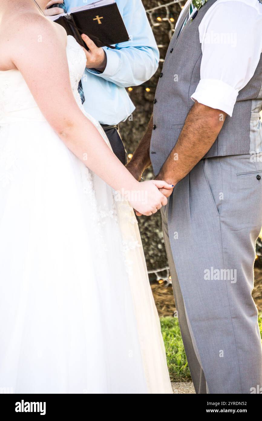 Mariée et mariée se tenant la main pendant la cérémonie de mariage Banque D'Images