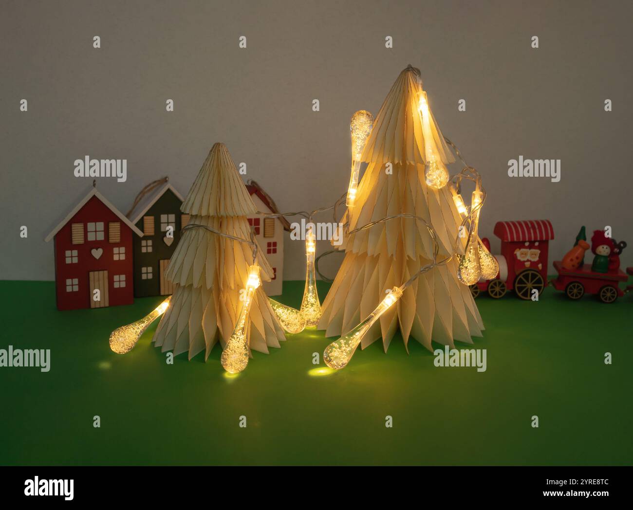 Arbre de Noël minimaliste avec des lumières et des figurines de noël sur fond vert. Concept minimal du nouvel an. Banque D'Images