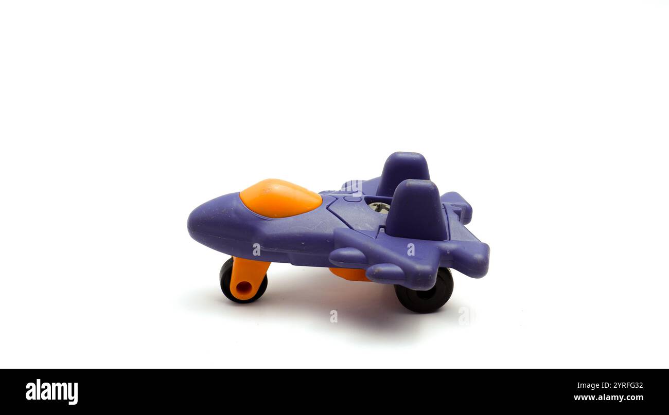 Un avion jouet en plastique violet pour les enfants, avec fond blanc isolé et règle de la composition photo des tiers Banque D'Images