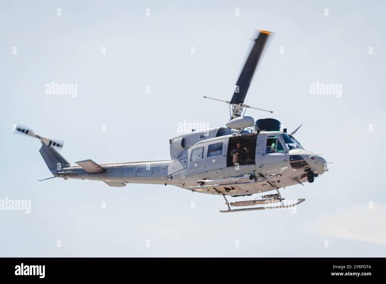 un hélicoptère militaire effectue un virage en survolant une zone lors de manœuvres de reconnaissance Banque D'Images