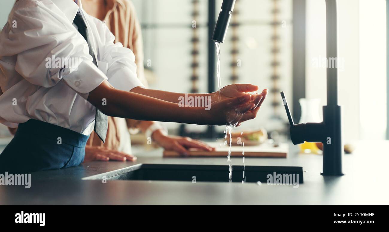 Maison, parent et fille avec se laver les mains dans la cuisine pour l'hygiène, les germes et les bactéries. Appartement, les gens et l'enfant en famille avec de l'eau à l'évier pour la saleté Banque D'Images