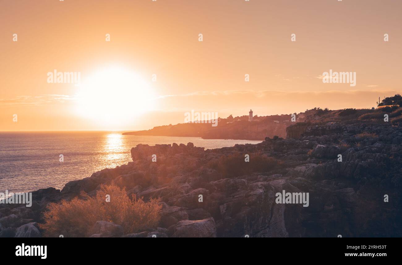 Le soleil couchant jette une lueur dorée chaude sur la côte accidentée de cascais, au portugal, créant une scène à couper le souffle de beauté naturelle et tranquille Banque D'Images