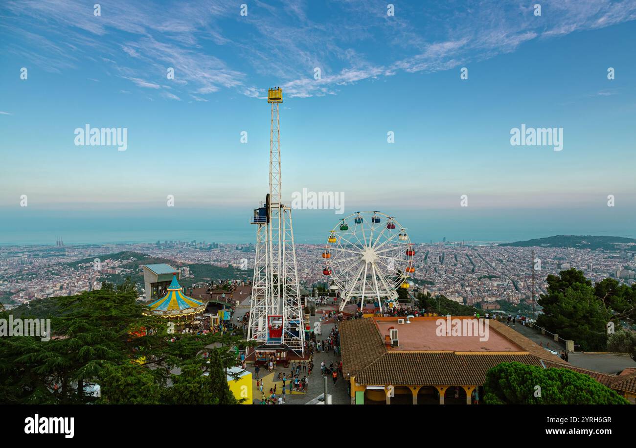 Admirez le coucher du soleil sur barcelone, la grande roue et la tour de chute s'élèvent pour créer une scène colorée depuis le mont tibidabo avec vue sur la mer méditerranée Banque D'Images
