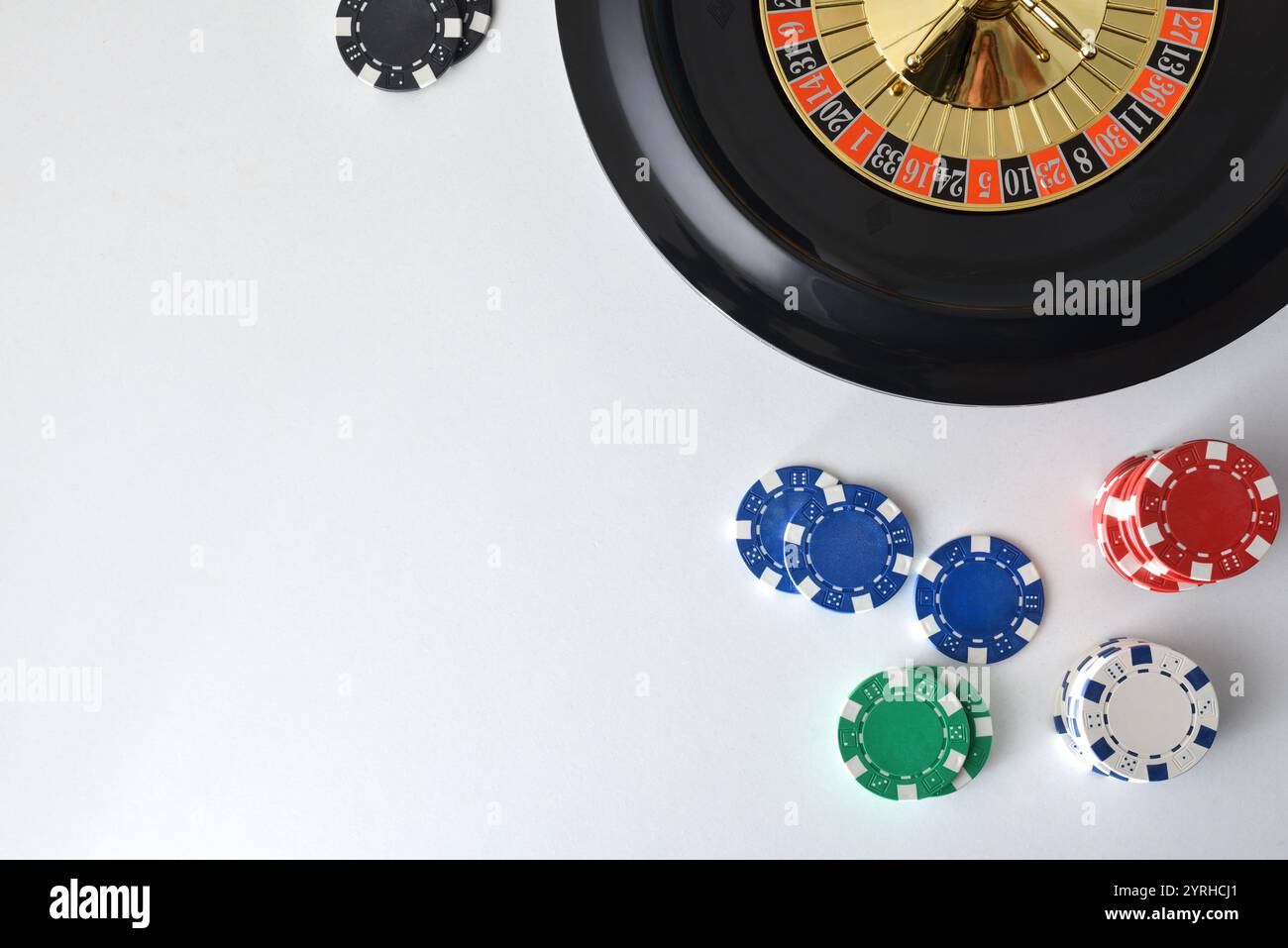 Roulette de casino isolé sur la table blanche avec des jetons colorés pour parier autour. Vue de dessus. Banque D'Images