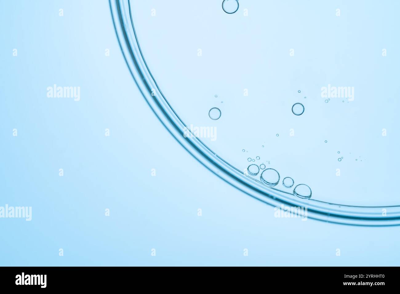 Une image minimaliste montrant de petites bulles à la surface d'un liquide transparent bleu clair. La simplicité et la clarté des bulles créent une suie Banque D'Images