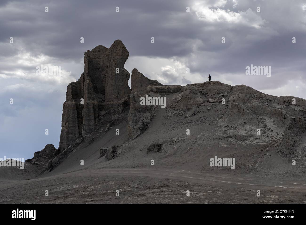 Une vue spectaculaire des formations accidentées de Factory Butte sous un ciel nuageux dans l'Utah, aux États-Unis le paysage saisissant présente des textures rocheuses et un aventurier Banque D'Images