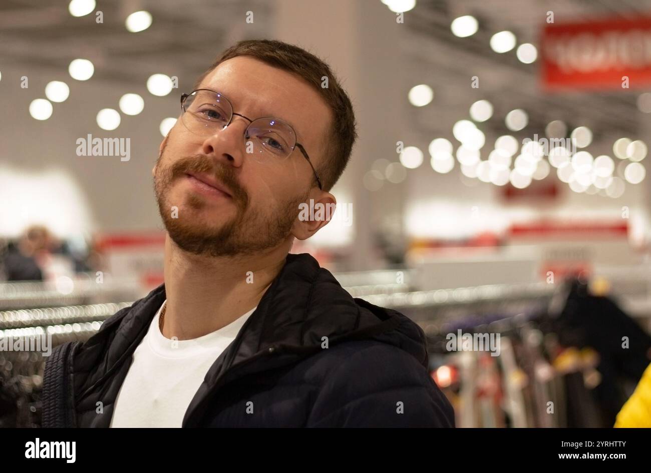 Un homme regarde des chaussures et des vêtements dans un magasin Banque D'Images