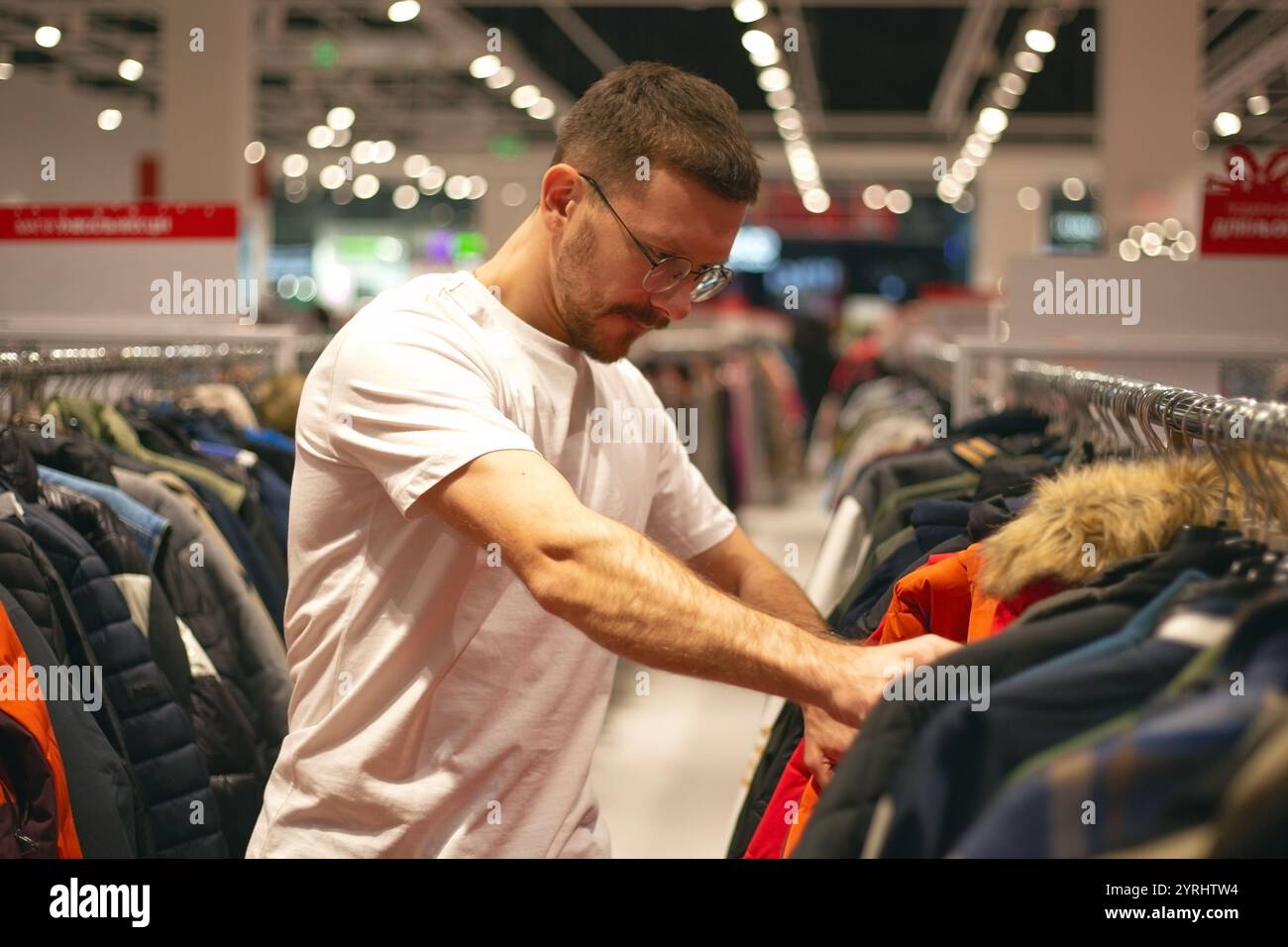 Un homme regarde des chaussures et des vêtements dans un magasin Banque D'Images