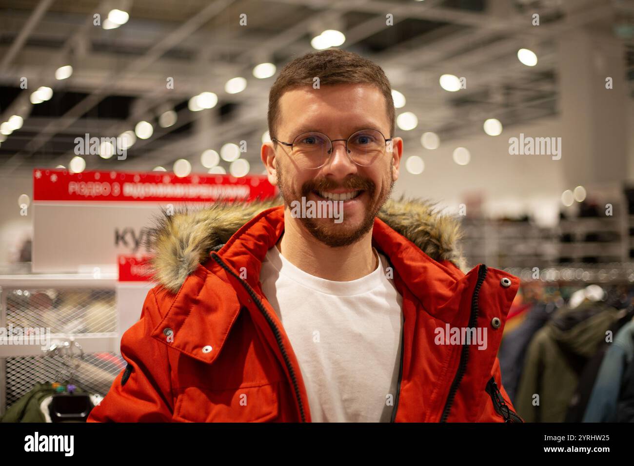 Un homme regarde des chaussures et des vêtements dans un magasin Banque D'Images