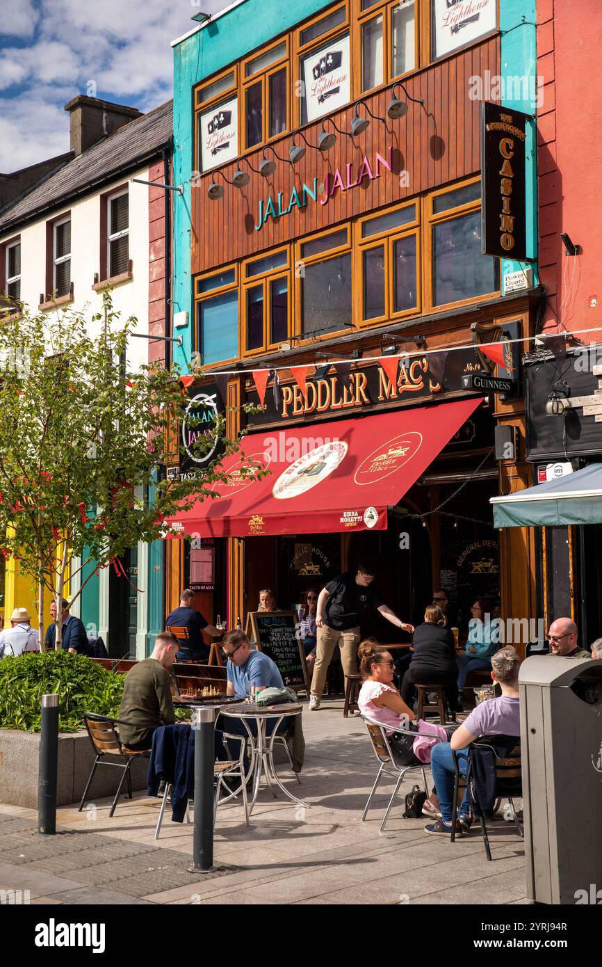 Irlande, comté de Westmeath, Athlone, Church Street, les clients assis sur la chaussée devant le Peddler Mac's Bar Banque D'Images