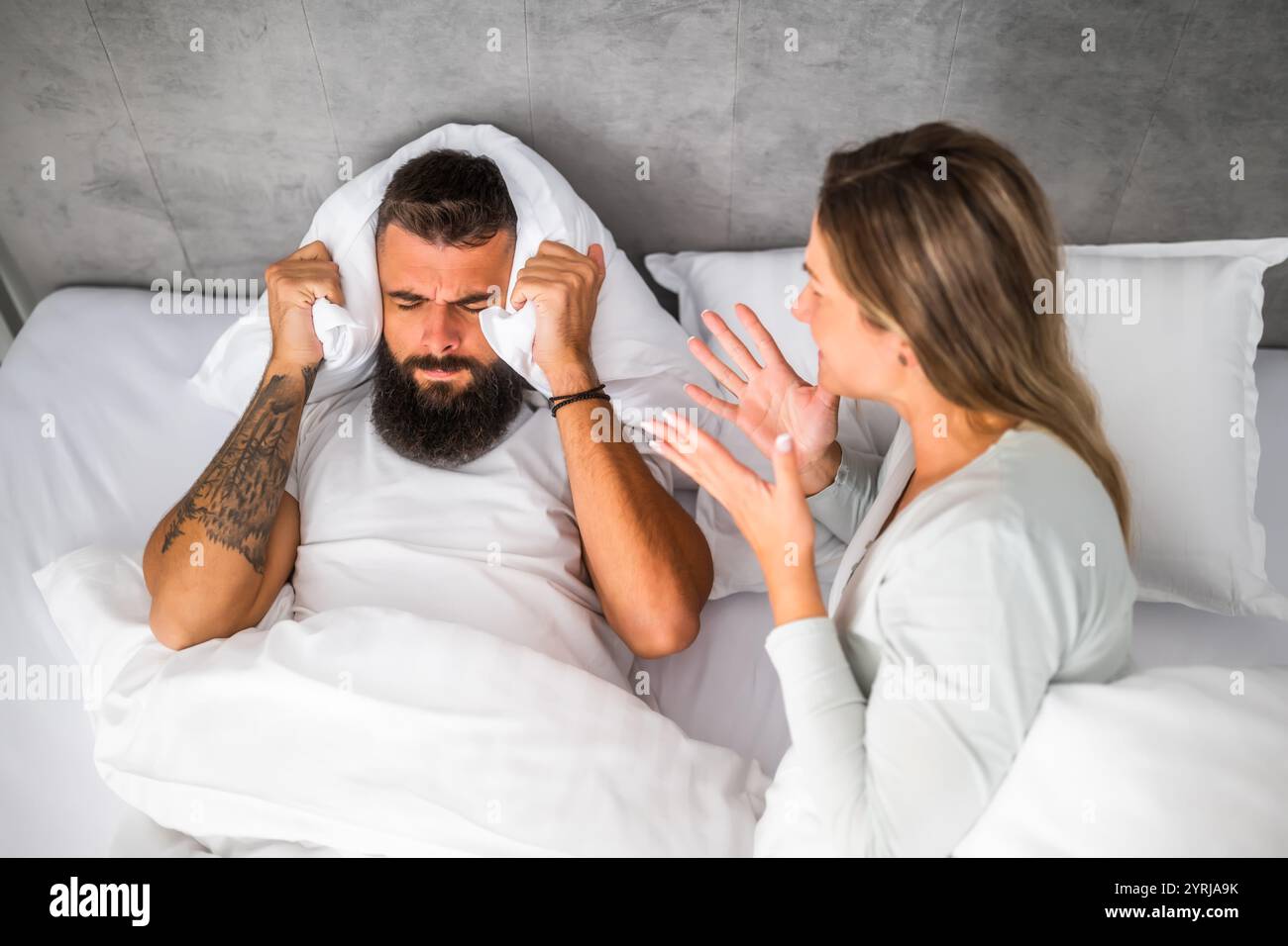 Le couple est allongé dans son lit et se dispute. La femme est en colère contre l'homme. Banque D'Images