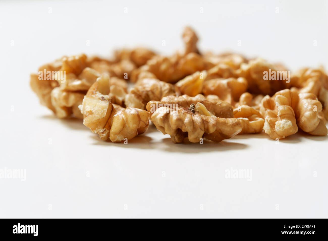 Moitiés de noix décortiquées (Juglans regia) sur fond blanc propre, concept de nourriture naturelle saine. Banque D'Images