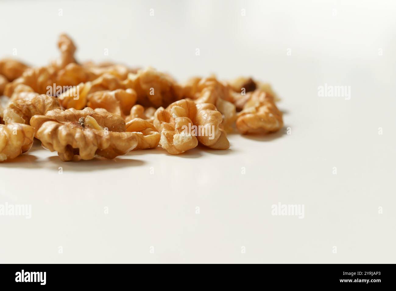 Moitiés de noix décortiquées (Juglans regia) sur fond blanc propre, concept de nourriture naturelle saine. Banque D'Images