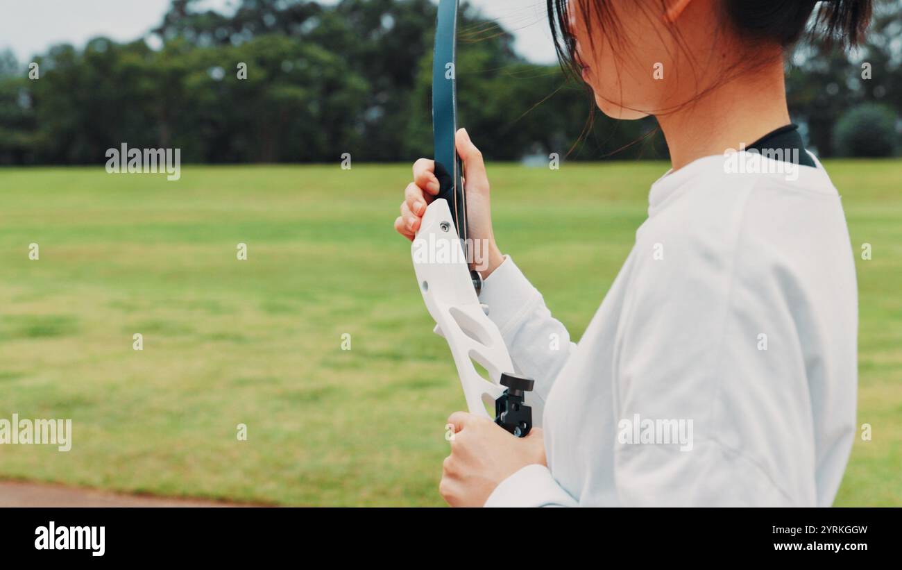 Fille, arc ou mains d'archer pour l'entraînement sportif, le terrain ou la préparation pour la compétition, l'équipement ou le jeu. Tir à l'arc, athlète ou champ de tir Banque D'Images