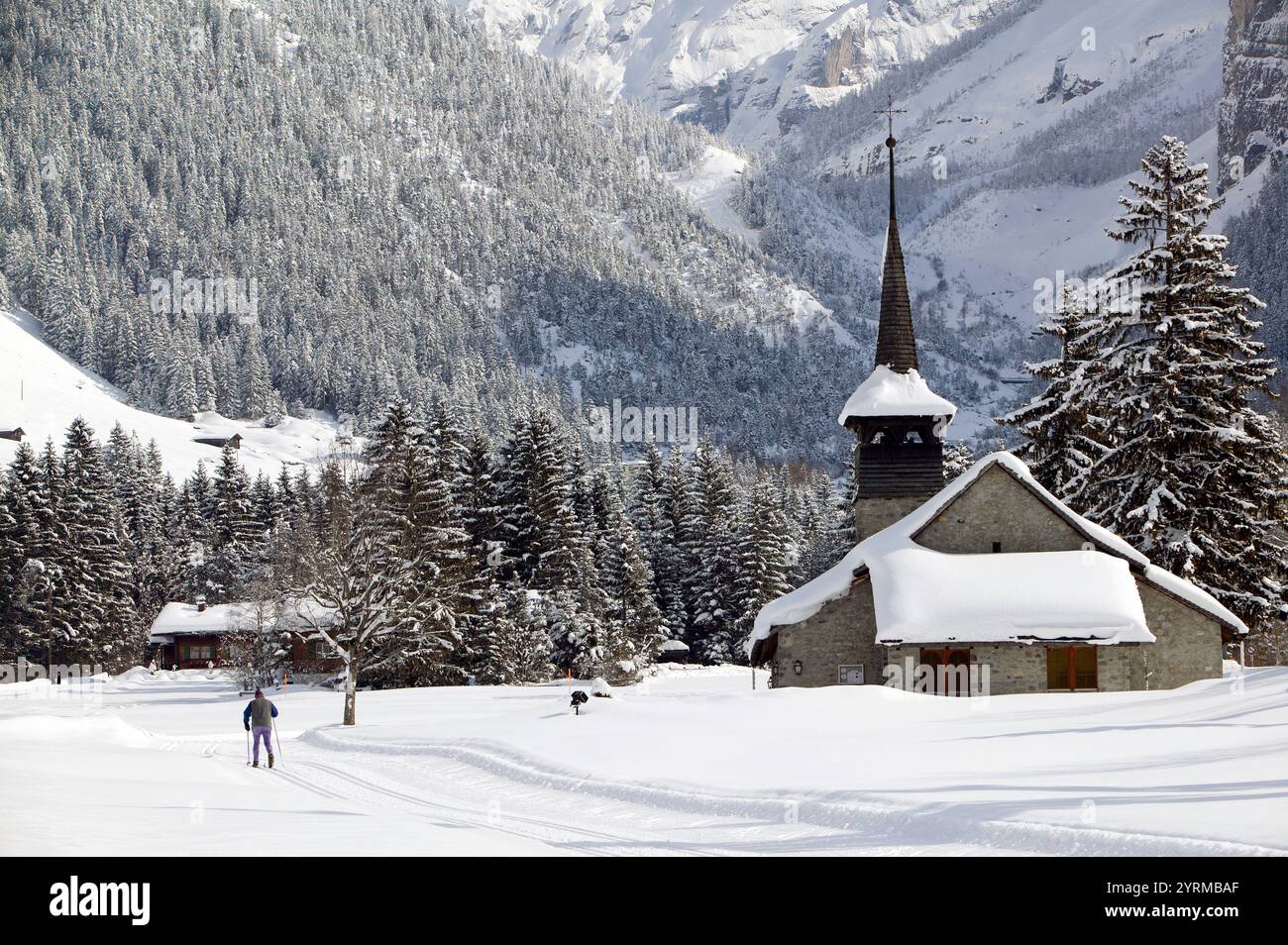 Vallée de Kandertal - Église de la ville et skieurs de fond / hiver. Kandersteg. Berne. Suisse. Banque D'Images