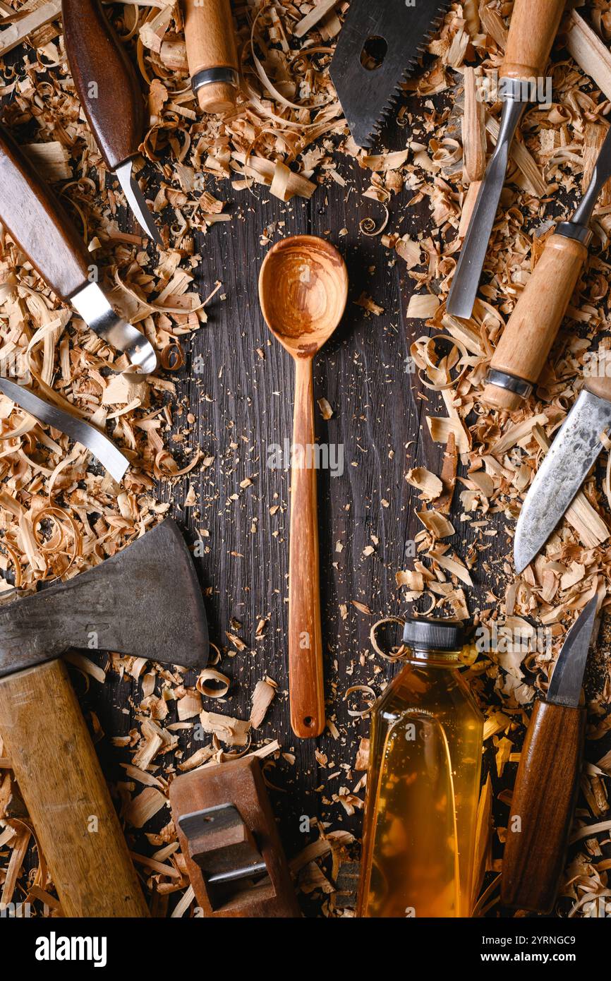 Cuillère en bois artisanale avec tas de limailles en bois avec différents outils de menuiserie manuelle. Concept de fabrication artisanale Banque D'Images