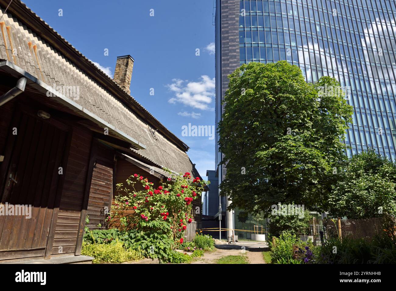 Vieilles maisons en bois entourées de tours de bureaux modernes dans le quartier de Snipiskes, Vilnius, Lituanie, Europe Banque D'Images