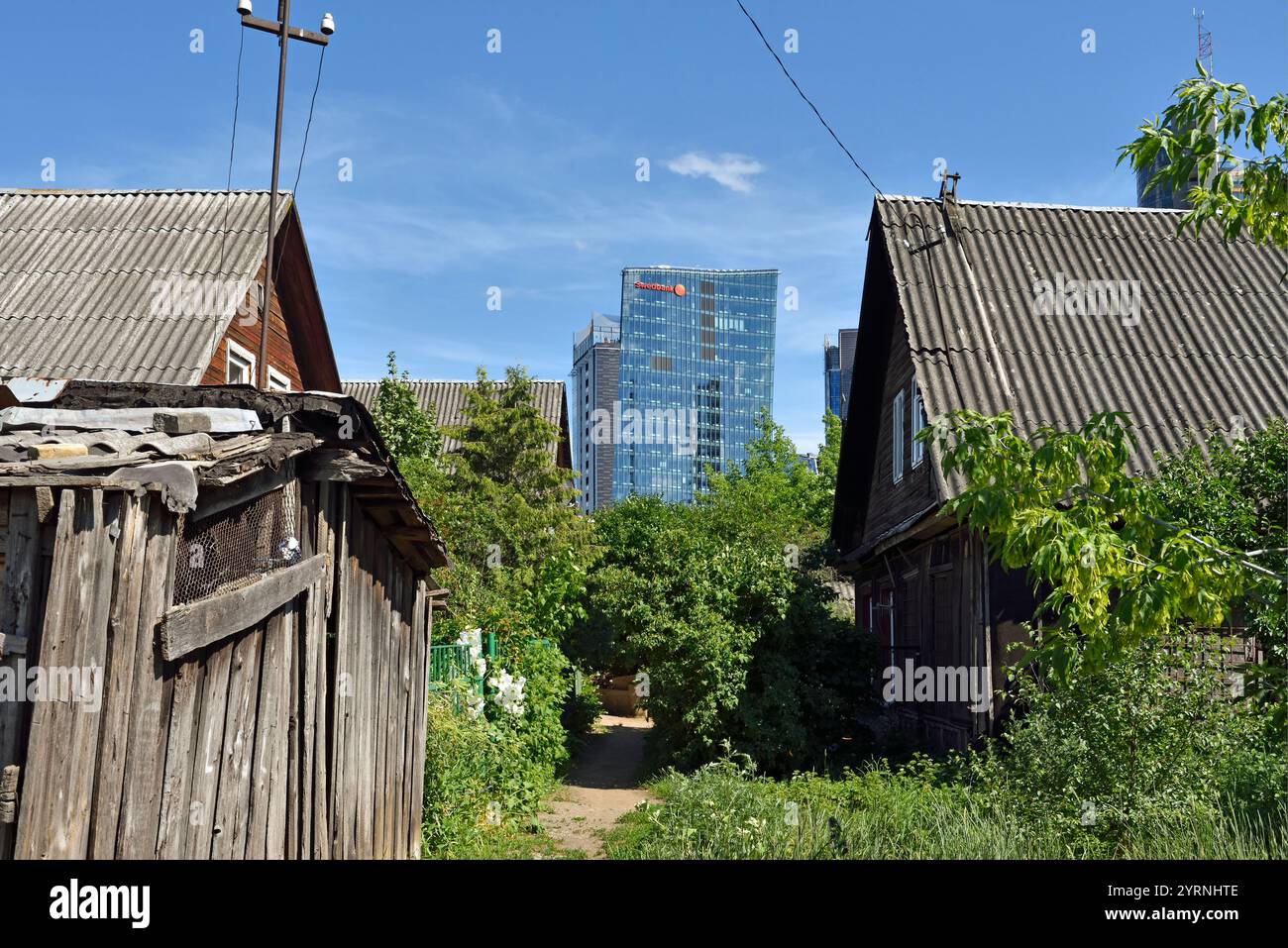 Vieilles maisons en bois entourées de tours de bureaux modernes dans le quartier de Snipiskes, Vilnius, Lituanie, Europe Banque D'Images
