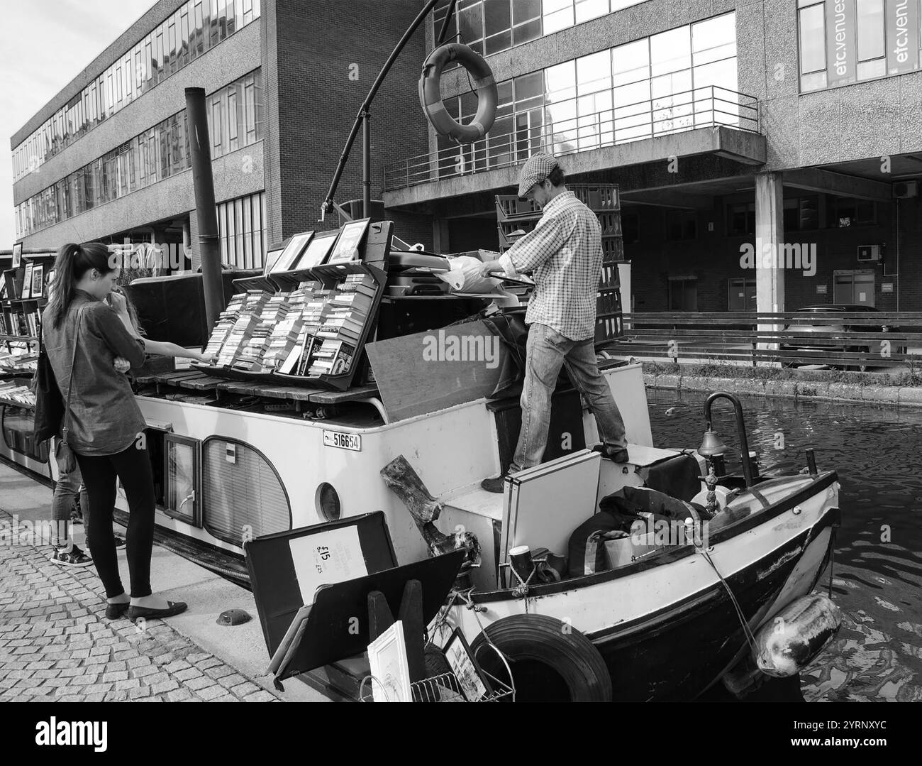 LONDRES, ANGLETERRE, Royaume-Uni - 5 MAI 2014 : les gens choisissent des livres à acheter à la librairie "Word on the Water", librairie sur la barge qui monte et descend Regents canal Banque D'Images
