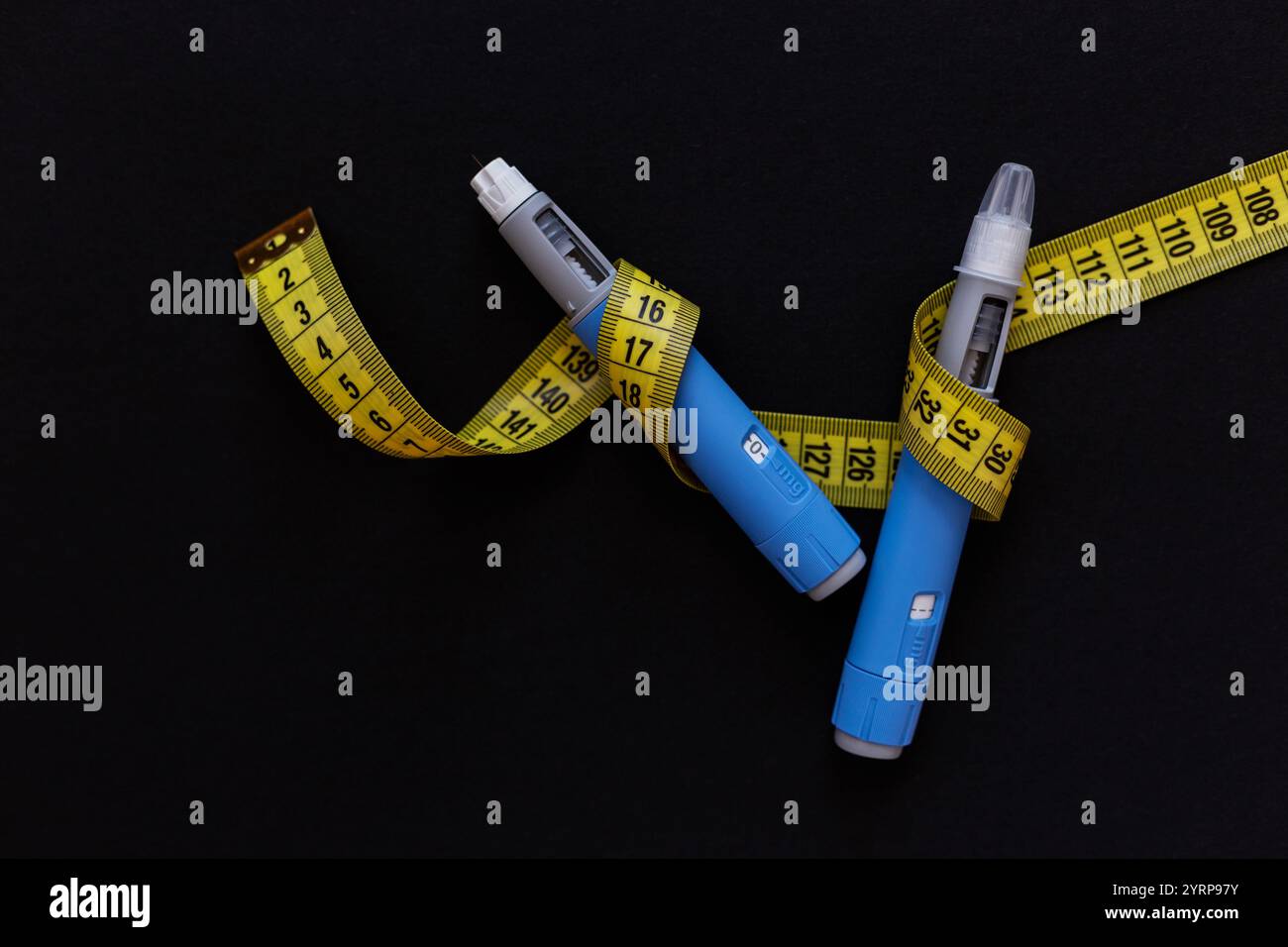 Injection de drogue ozempic avec un ruban à mesurer jaune sur fond noir. Stylo injecteur d’insuline Ozempic ou stylo cartouche d’insuline pour diabétiques. Médical Banque D'Images