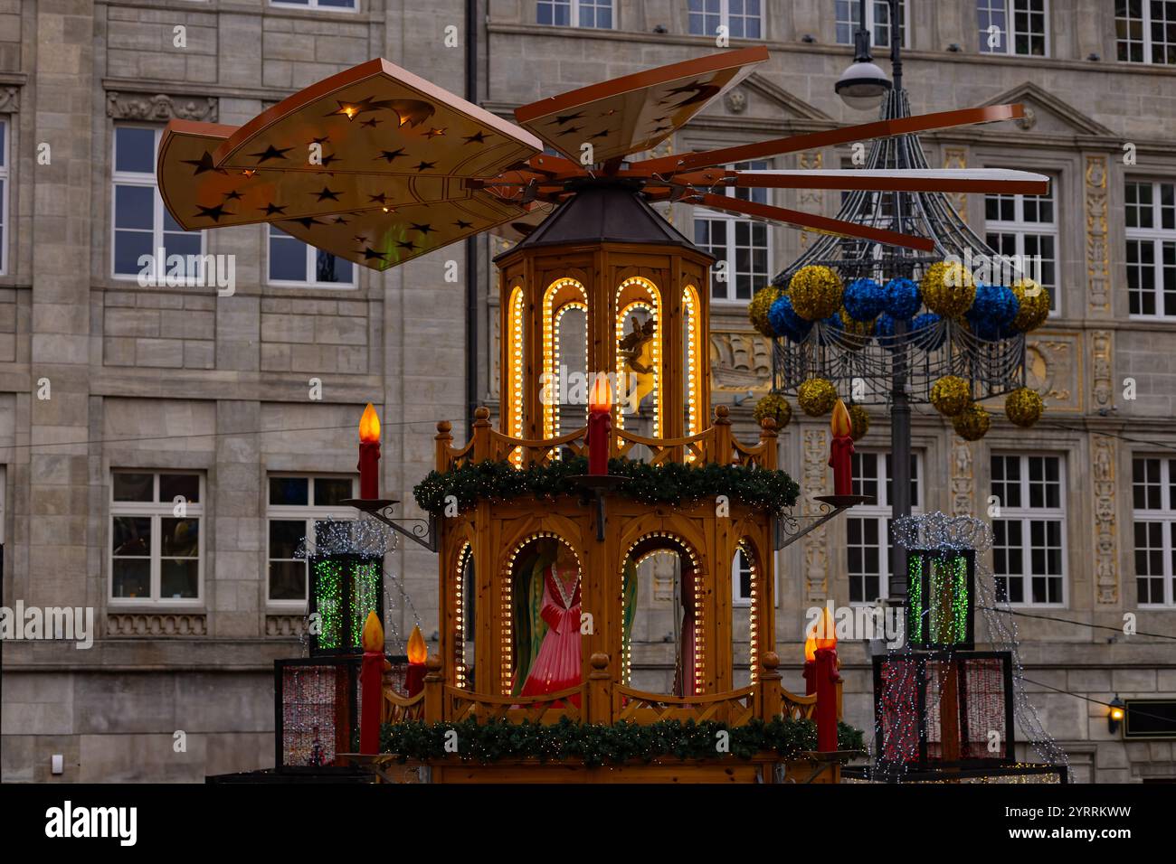 Marché de Noël traditionnel à Wroclaw avec pyramide en bois festive, bougies brillantes, décorations de vacances et architecture de la ville en arrière-plan Banque D'Images
