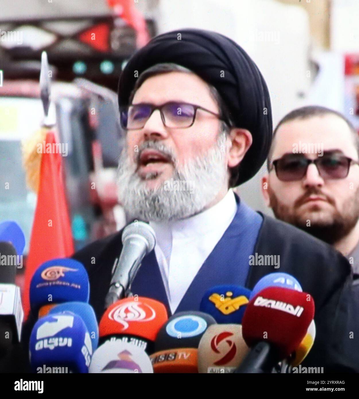 Couverture médiatique télévisée de Hashem Safieddine (1964 ? 3 octobre 2024) un religieux chiite libanais qui dirige le Conseil exécutif du Hezbollah depuis 2001. Cousin maternel de Hassan Nasrallah, Safieddine était généralement considéré comme le « numéro deux » du Hezbollah avant l'assassinat de Nasrallah le 27 septembre 2024. Le 3 octobre 2024, Safieddine a été la cible d'une frappe aérienne israélienne à Beyrouth. Le 5 octobre, il a été signalé que le Hezbollah avait perdu contact avec Safieddine depuis la frappe aérienne. Le 8 octobre, le ministre israélien de la Défense Yoav Gallant a déclaré que Safieddine était probablement 'elim Banque D'Images