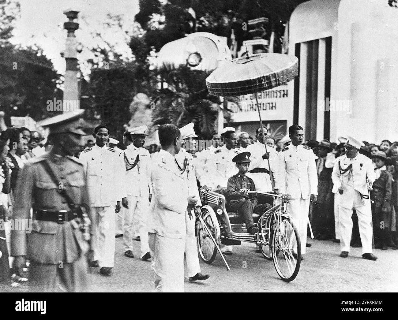 Mahidol sur un tricycle dans le palais royal marchant au centre. Suivi par son frère le prince Bhumibol 1938. Ananda Mahidol (20 septembre 1925 ? 9 juin 1946) roi du Siam (plus tard Thaïlande) de la dynastie Chakri, titré Rama VIII au moment où il a été reconnu comme roi par l'Assemblée nationale en mars 1935, il était un garçon de neuf ans vivant en Suisse. Il est retourné en Thaïlande en décembre 1945, mais six mois plus tard, en juin 1946, il a été retrouvé abattu dans son lit. sa mort a été déclarée meurtre par les médecins légistes, et trois aides royales ont été exécutées plus tard à la suite de procès très irréguliers. Suivant Banque D'Images