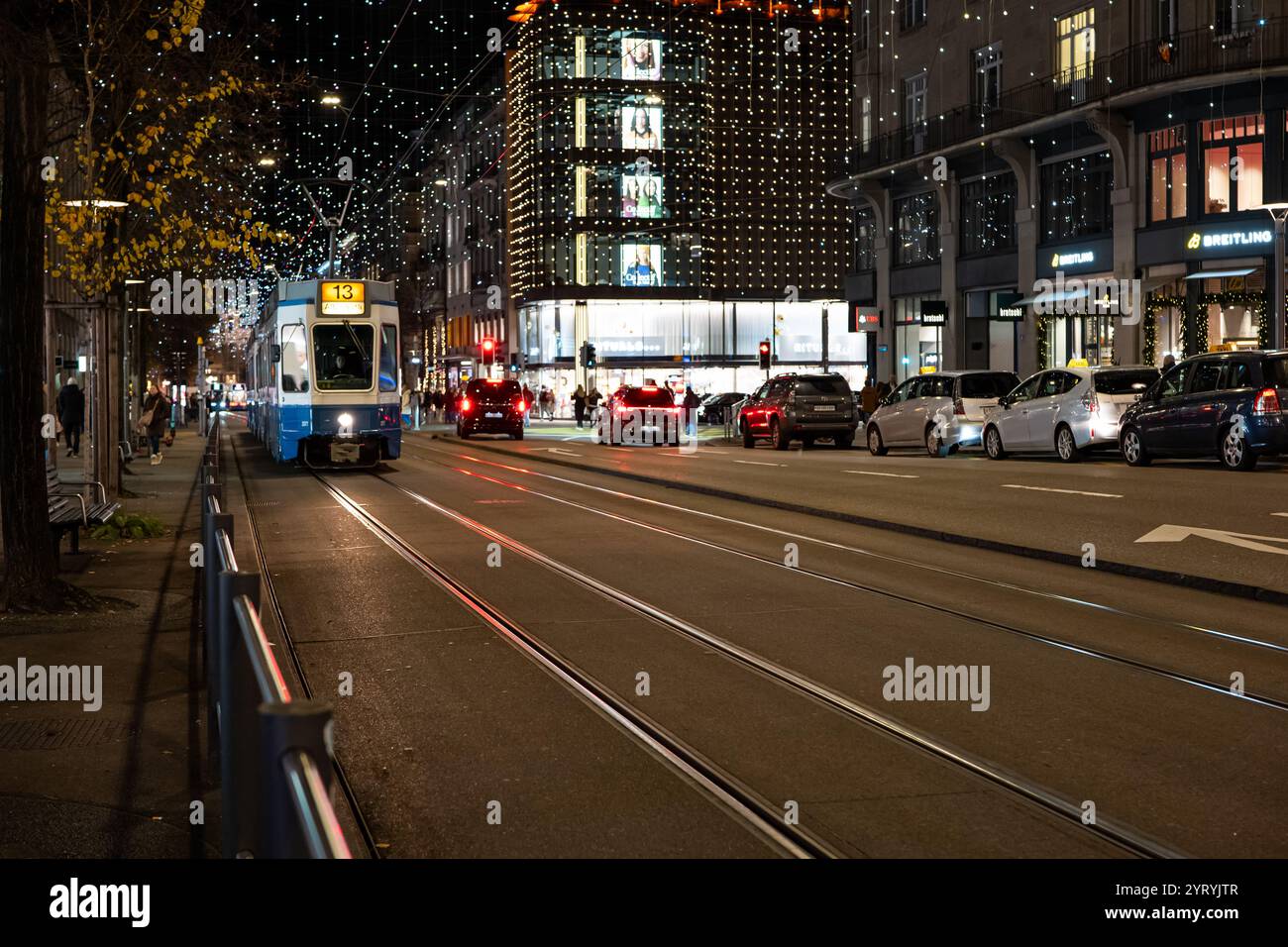 3-12-2024 Zurich, Suisse. Tramway vintage numéro 13 sur Bahnhofstrasse la nuit. Lumière de décoration de Noël suspendue d'en haut, scène nocturne. Banque D'Images