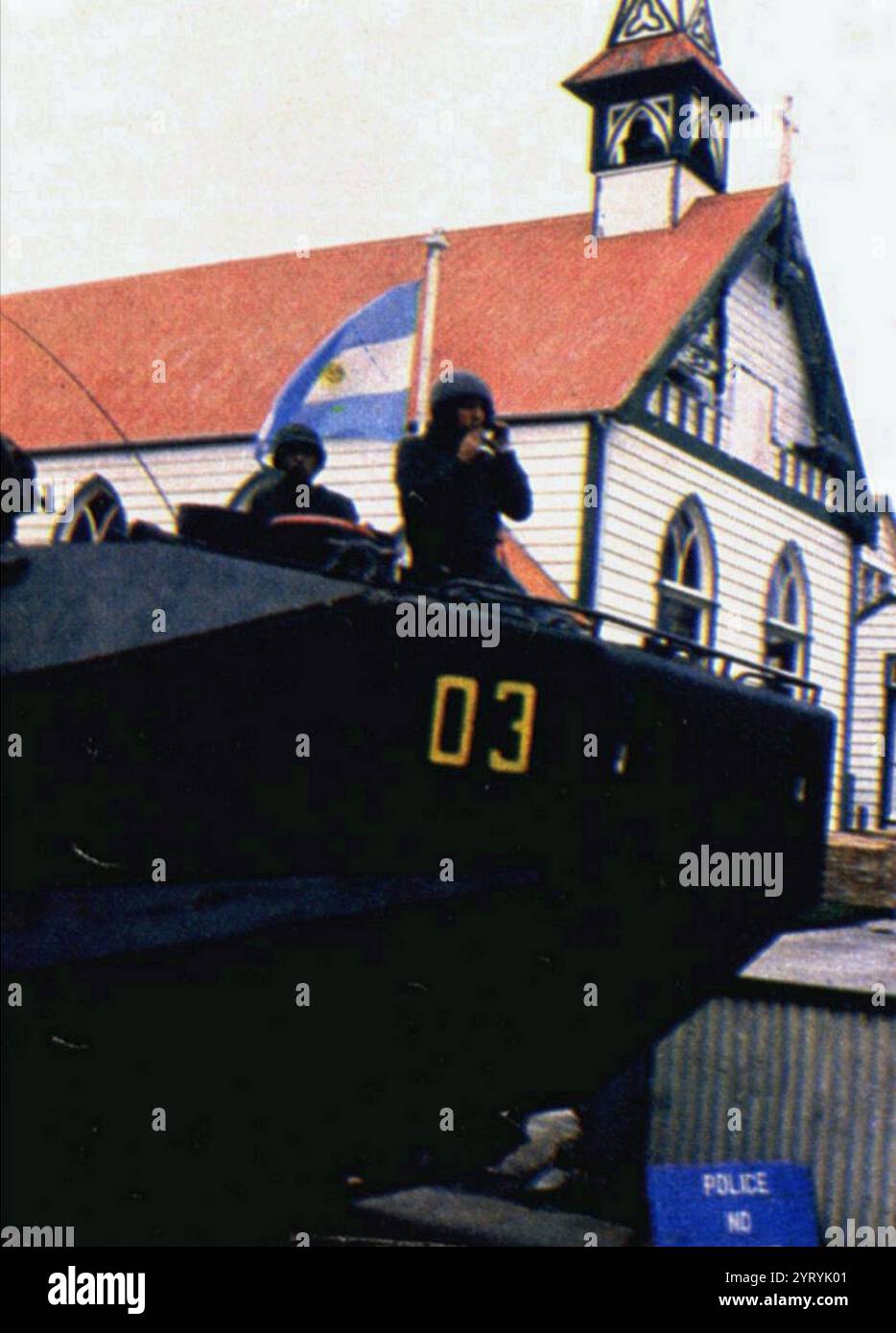 Le drapeau argentin flotte à côté d'un véhicule blindé à Port Stanley après que les forces argentines ont capturé les Malouines en 1982 Banque D'Images