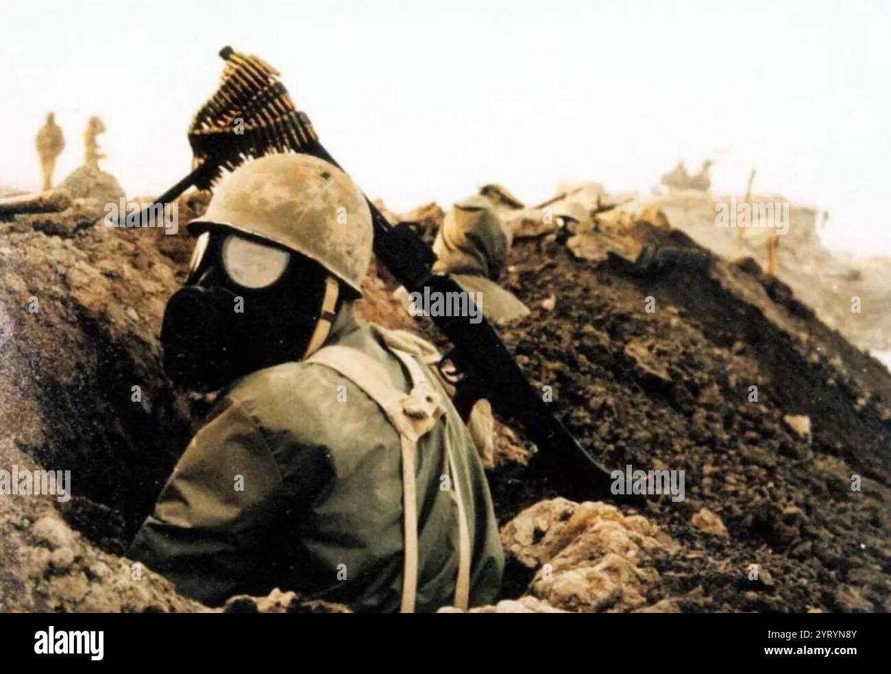 Un soldat iranien portant un masque à gaz et un casque M1 pendant la guerre Iran-Irak. 1985 Banque D'Images