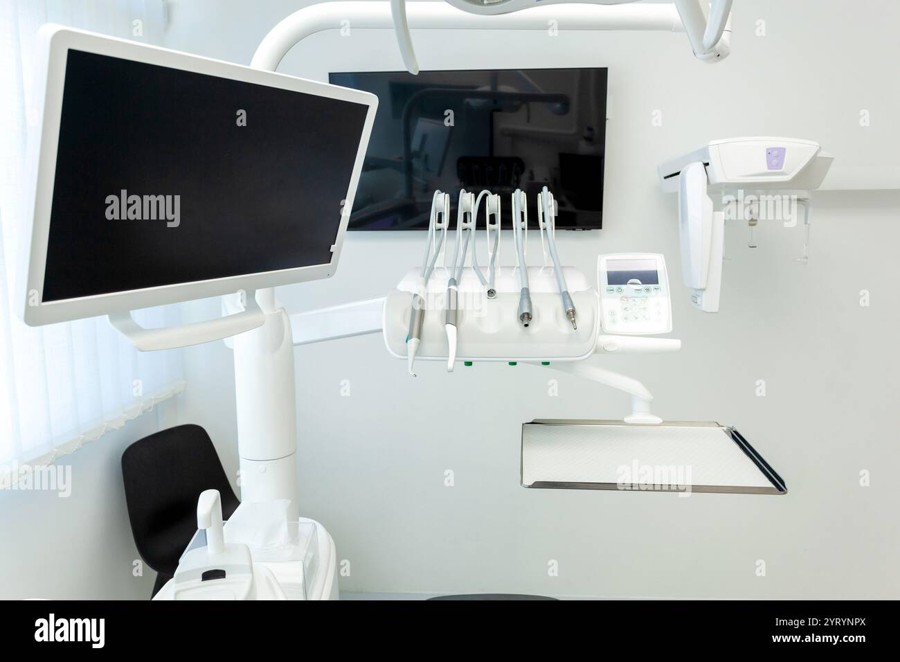 Clinique dentaire contemporaine présentant de l'équipement de haute technologie, y compris un moniteur, des outils dentaires et un appareil à rayons X, mettant l'accent sur la dentisterie moderne Banque D'Images