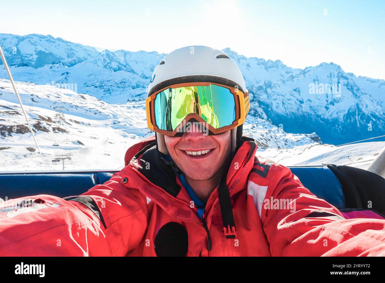 Heureux skieur prenant la photo selfie avec la caméra de téléphone intelligent assis sur le téléski - jeune homme s'amusant dans la station de neige d'hiver - Sport et concept de vacances Banque D'Images
