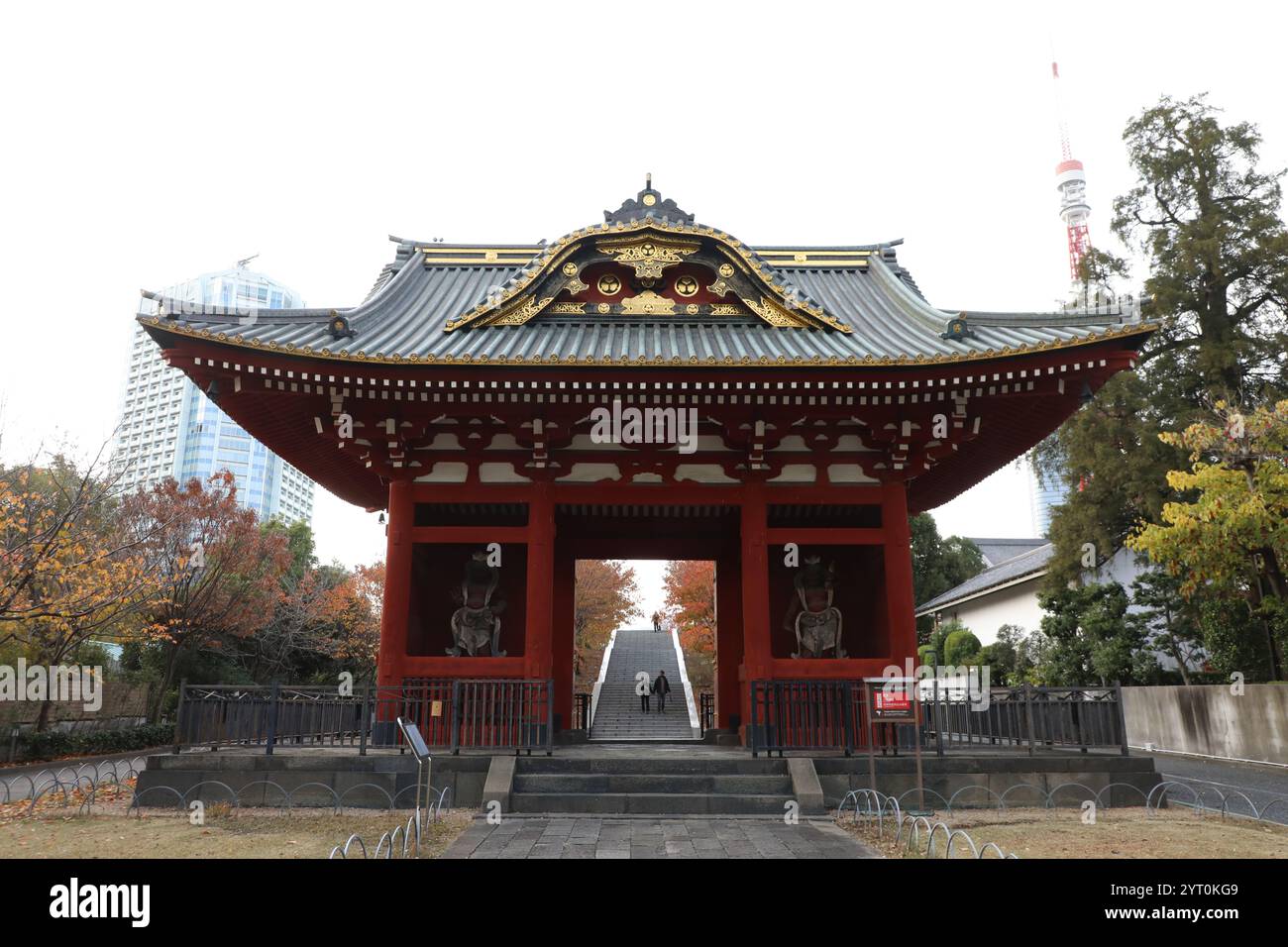 Ancienne porte du mausolée Taitoku-in, Shiba Park, Minato-Ku, Tokyo, Japon. En arrière-plan, la tour de Tokyo, officiellement la tour de radio japonaise. Banque D'Images