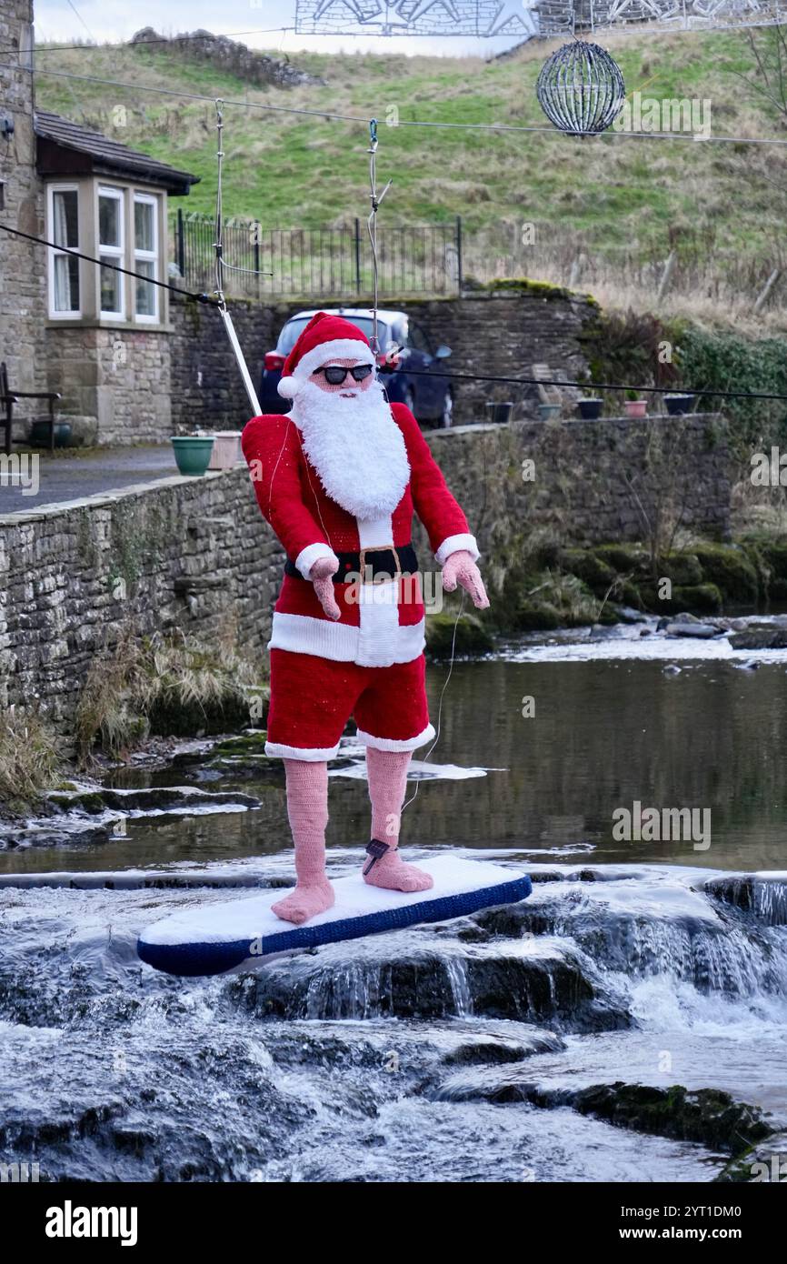 Un père Noël surfeur tricoté grandeur nature au-dessus de Gayle Beck. Banque D'Images