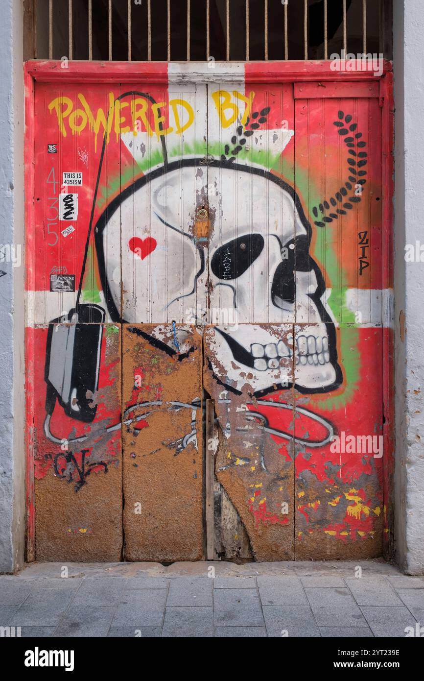 Graffito avec un crâne et des os croisés dans le centre historique de Valence Banque D'Images