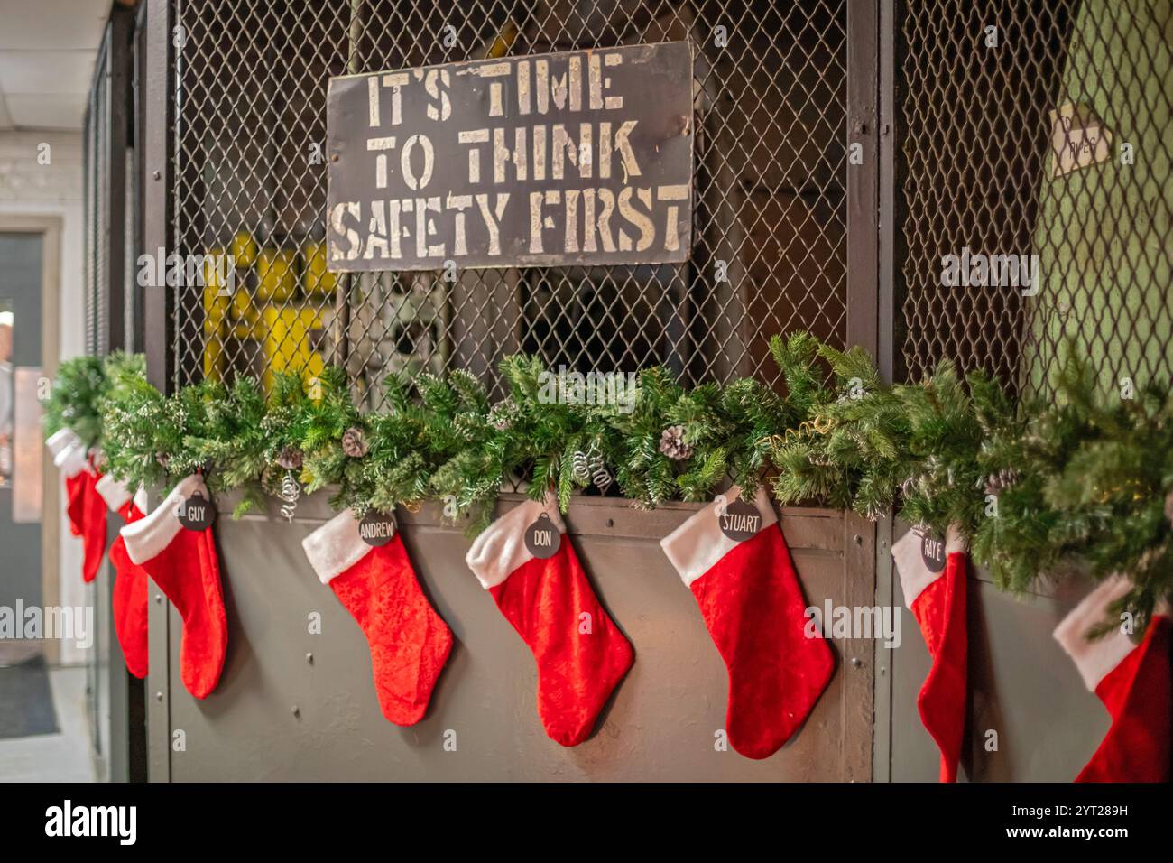 Thomas, Ontario Canada - des bas de Noël sont suspendus sous un panneau « la sécurité d'abord » au Musée ferroviaire du comté d'Elgin. Banque D'Images