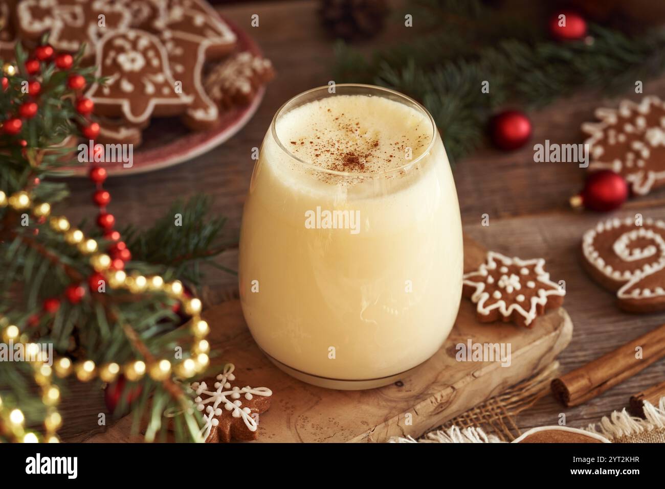 Un verre de lait de poule maison avec des biscuits de Noël en pain d'épices sur une table en bois Banque D'Images