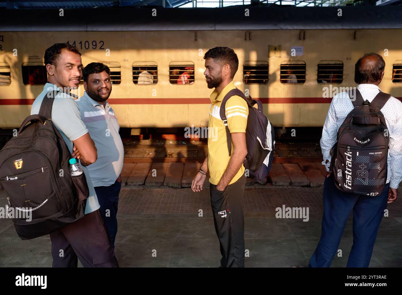 Voyageurs de chemin de fer masculins attendant un train de banlieue de la Central Line, debout sur un quai à la gare de Dadar à Mumbai, en Inde Banque D'Images