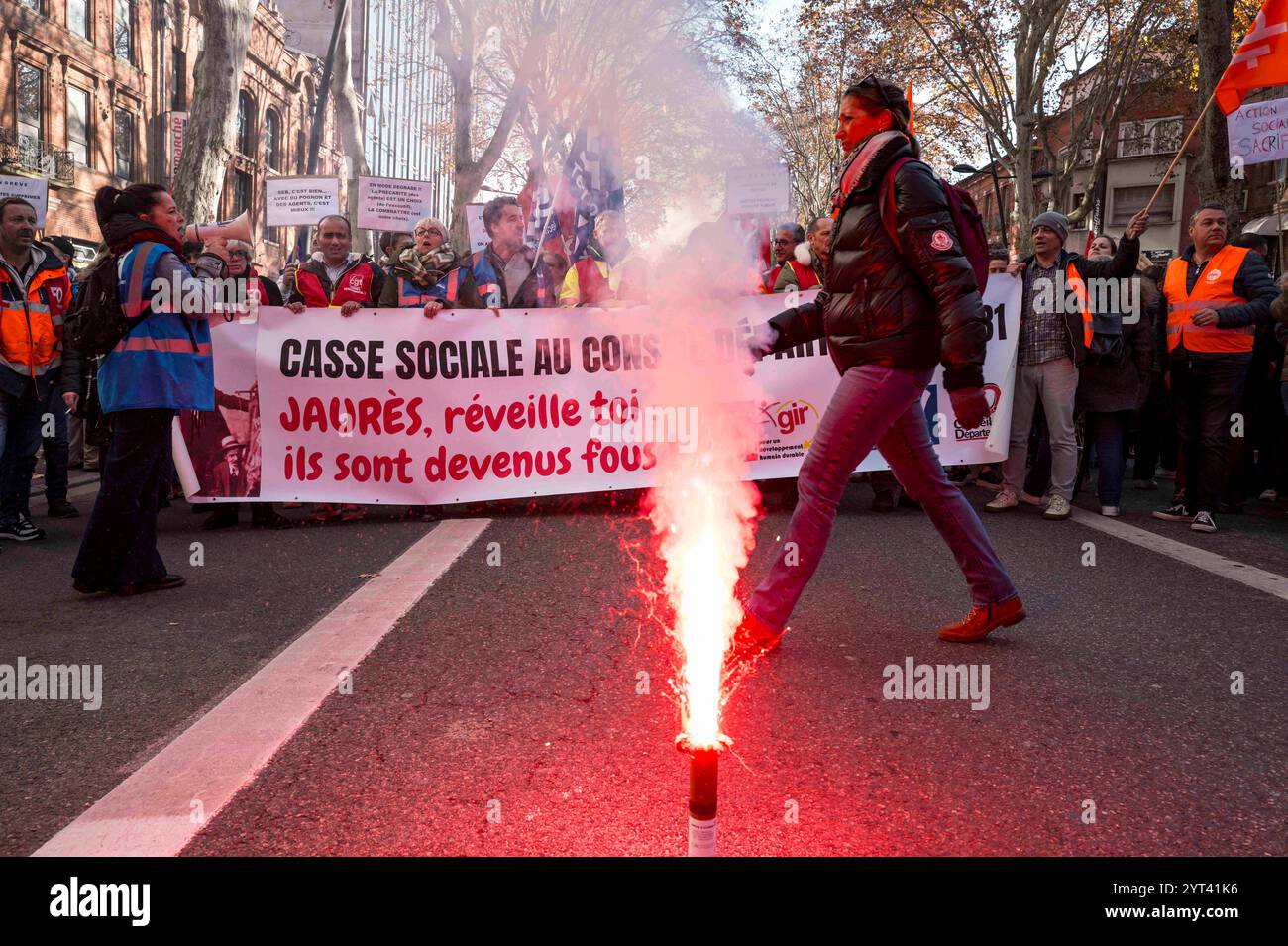 Toulouse, France. 05 novembre 2024. Une bombe fumigène rouge au sol avec la bannière en arrière-plan, social Breakdown at Department council 31. Jaurès, réveille-toi, avec un démonstrateur au milieu. La fonction publique est en grève dans toute la France. Grève et manifestation, écoles, hôpitaux, services publics, énergie à Toulouse. France, Toulouse 5 décembre 2024. Photo de Patricia Huchot-Boissier/ABACAPRESS. COM Credit : Abaca Press/Alamy Live News Banque D'Images