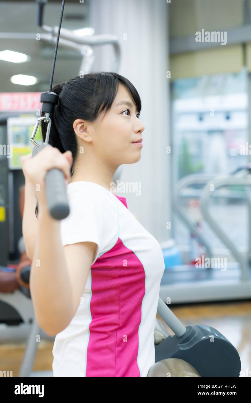 Jeunes femmes faisant de la musculation dans un gymnase sportif Banque D'Images