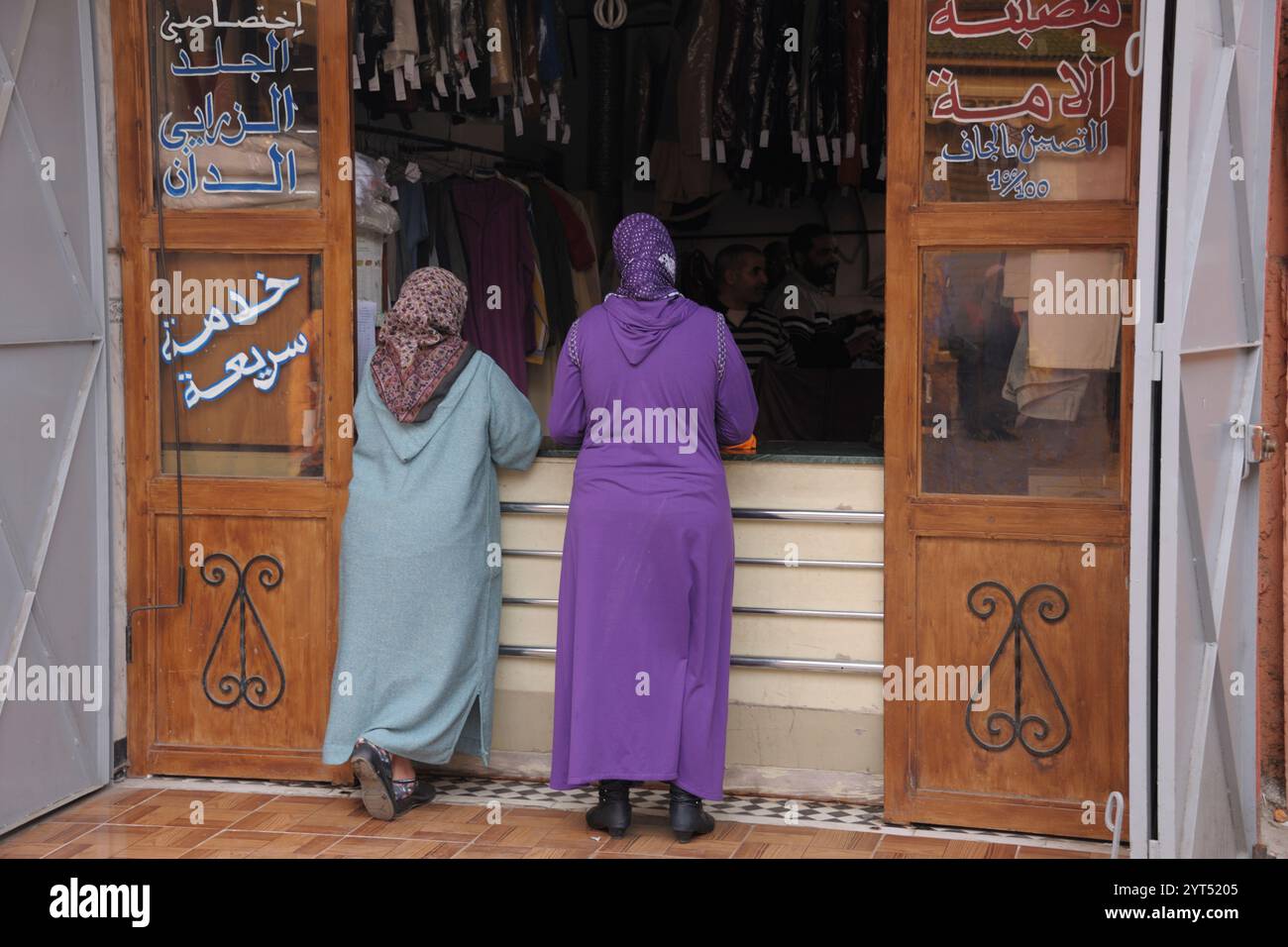Marrakech femme parlant dans un magasin de nettoyage à sec à Medina, Marrakech Banque D'Images