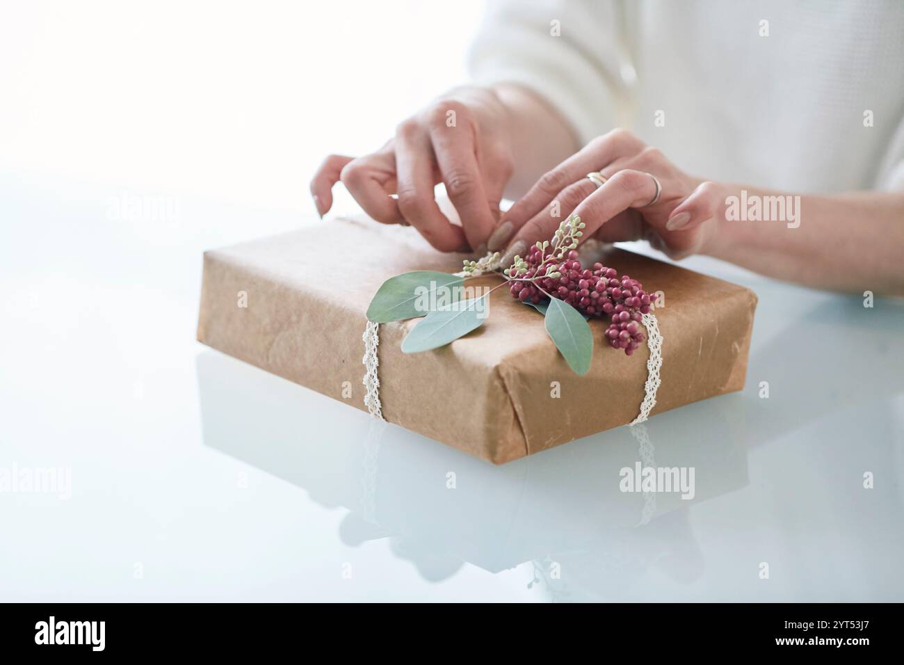 Main de femme enveloppant un cadeau Banque D'Images