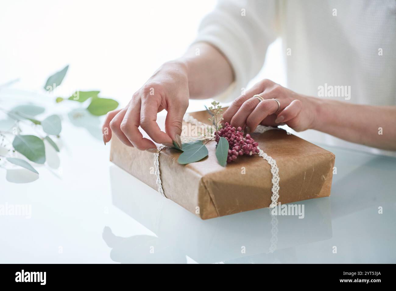 Main de femme enveloppant un cadeau Banque D'Images