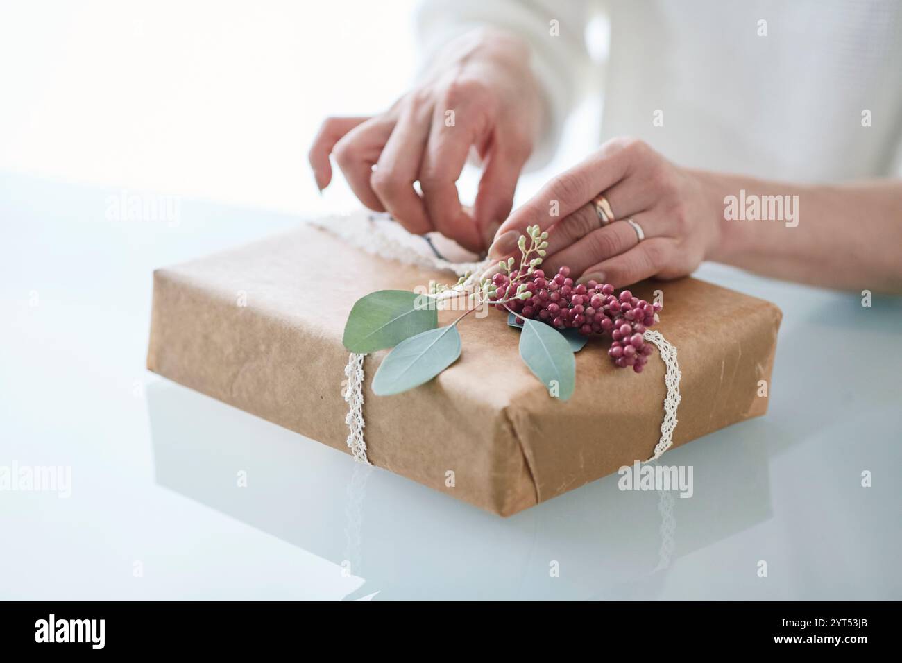 Main de femme enveloppant un cadeau Banque D'Images