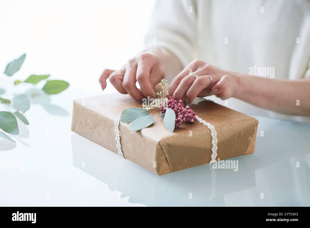 Main de femme enveloppant un cadeau Banque D'Images